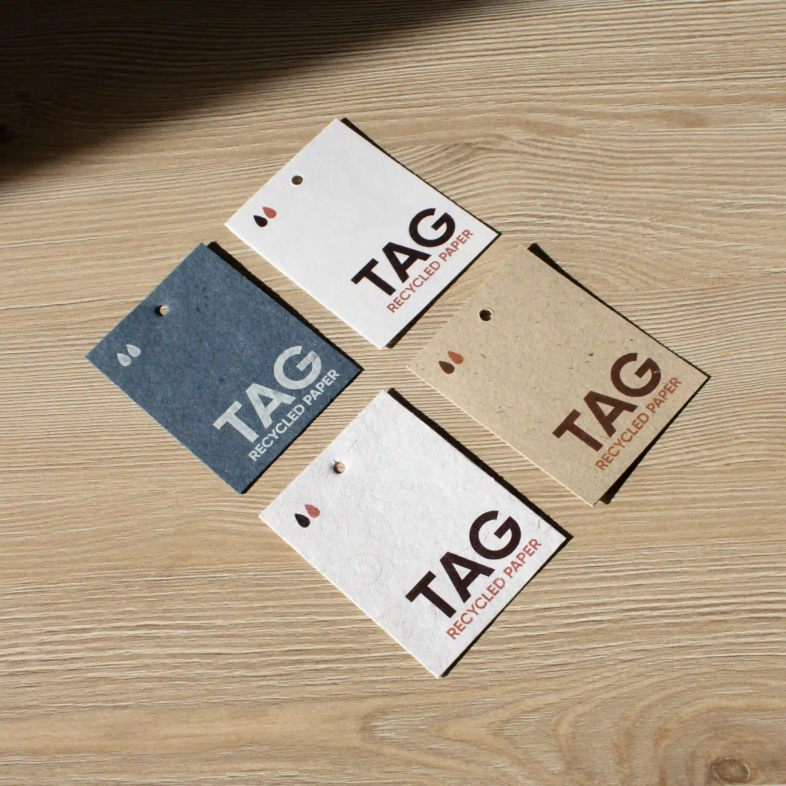 cuatro tarjetas de visita impresas en papeles ecológicos sobre una superficie de madera