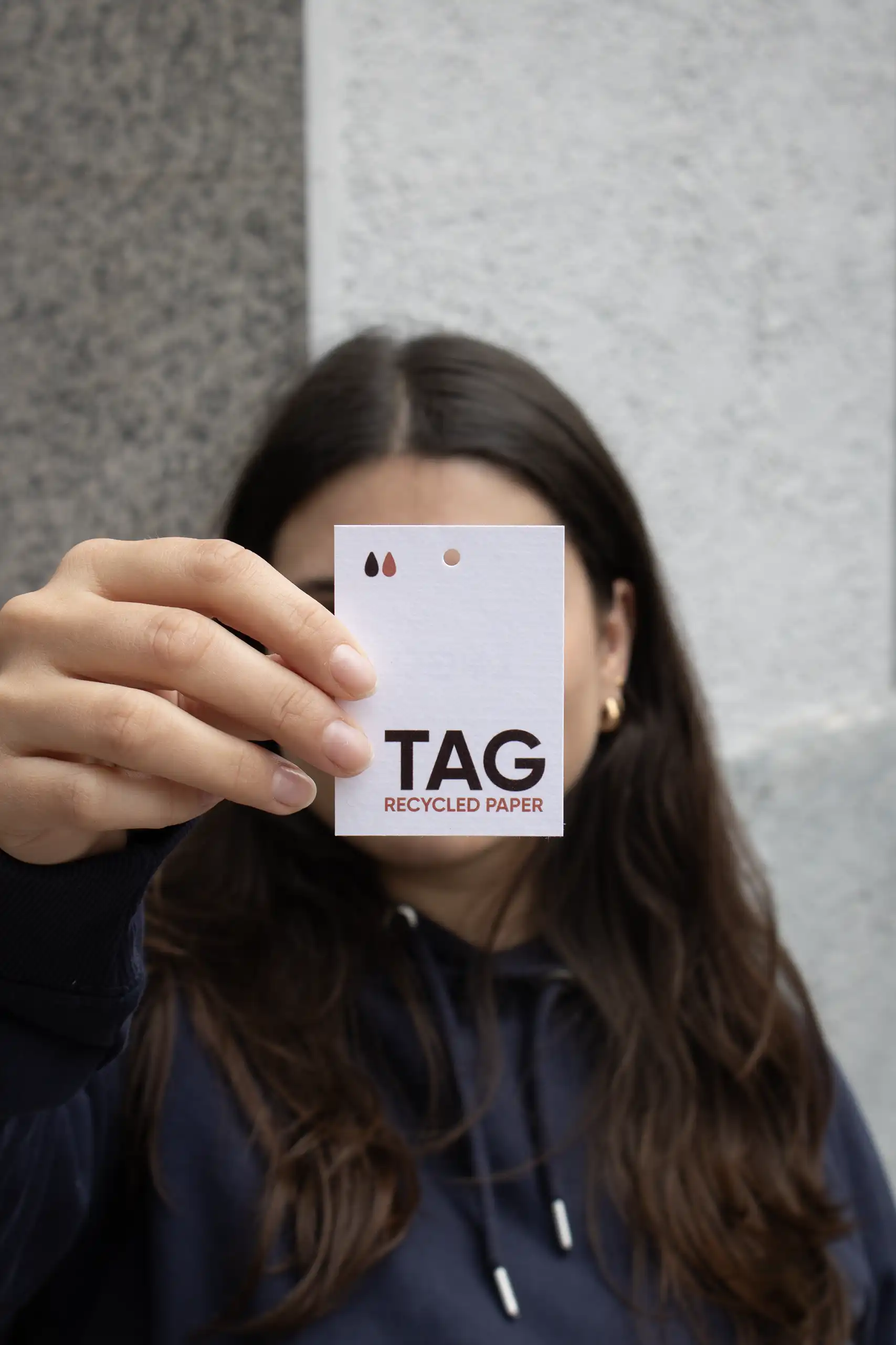 Chica mostrando a cámara una etiqueta impresa en papel ecológico
