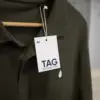 Una etiqueta de ropa impresa en papel plantable colgada de un polo verde