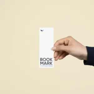 Una mano mostrando un marcapáginas de papel plantable personalizado