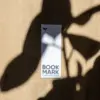 Marcapáginas de papel plantable personalizado sobre una superficie de madera con sombras