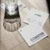 Posavasos de papel plantable Tres posavasos de papel plantable personalizados y un vaso de cristal sobre una superficie de madera al sol