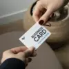 Dos manos sujetando una tarjeta de visita impresa en papel plantable