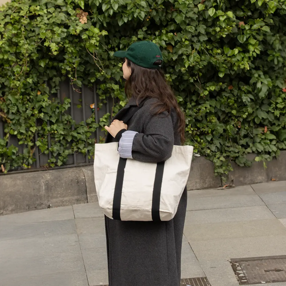 Una chica en el exterior con tote bag de algodón con asas negras