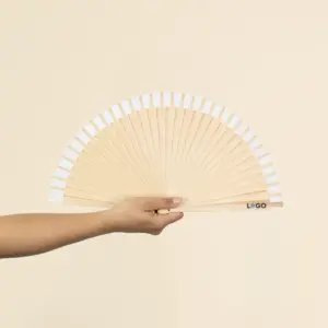 Mano sujetando un abanico de madera y algodón abierto