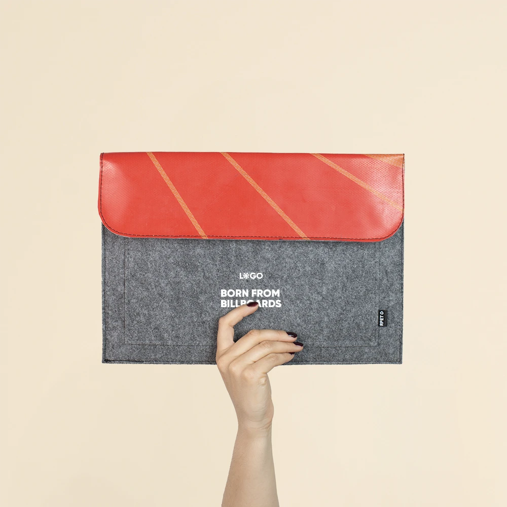 Mano mostrando una funda de portátil personalizada hecha con fieltro y lona roja reciclada