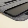 Funda de portátil de fieltro entreabierta con un portátil negro