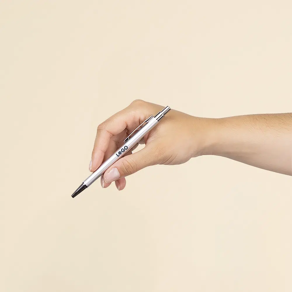 Bolígrafo de aluminio reciclado GANTE Mano sujetando un bolígrafo plateado de aluminio reciclado personalizado con la palabra LOGO en azul oscuro