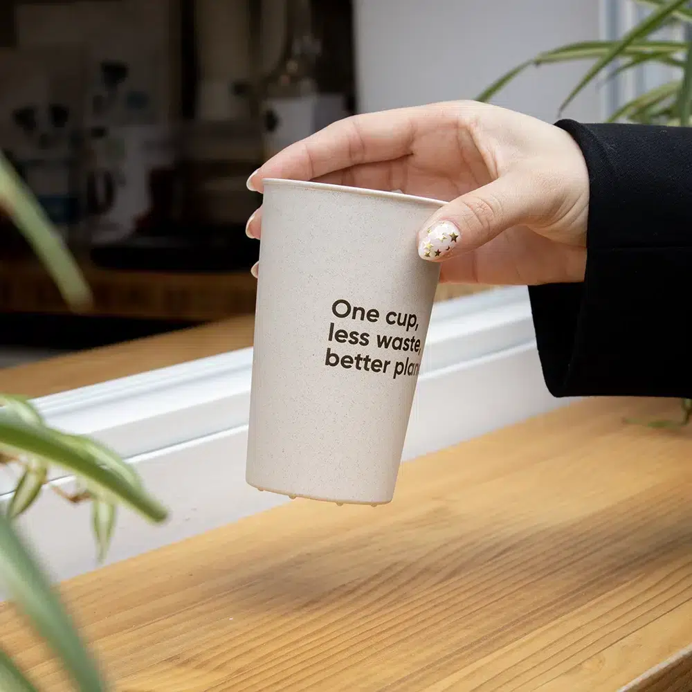 Mano sujetando vaso reutilizable de cáscara de arroz