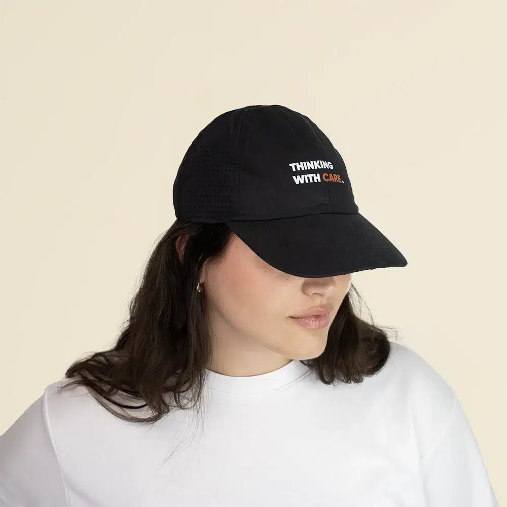 Chica con una gorra personalizable con visera deportiva sobre un fondo beige