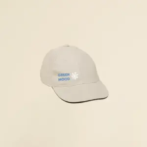 Gorra beige con logo lateral en un fondo beige