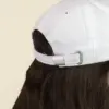Parte trasera de una gorra blanca en un fondo beige