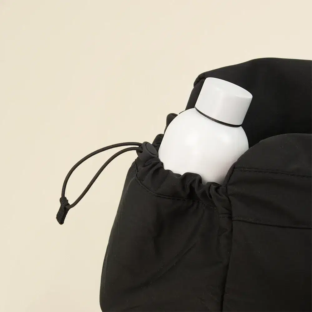 Bolsa de deporte PULSE Botella blanca en uno de los bolsillos de una bolsa de deporte negra de poliƩster reciclado