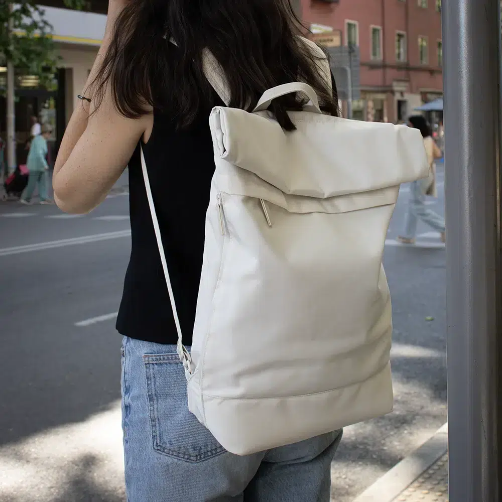 Chica con una mochila roll top personalizada blanca en su espalda