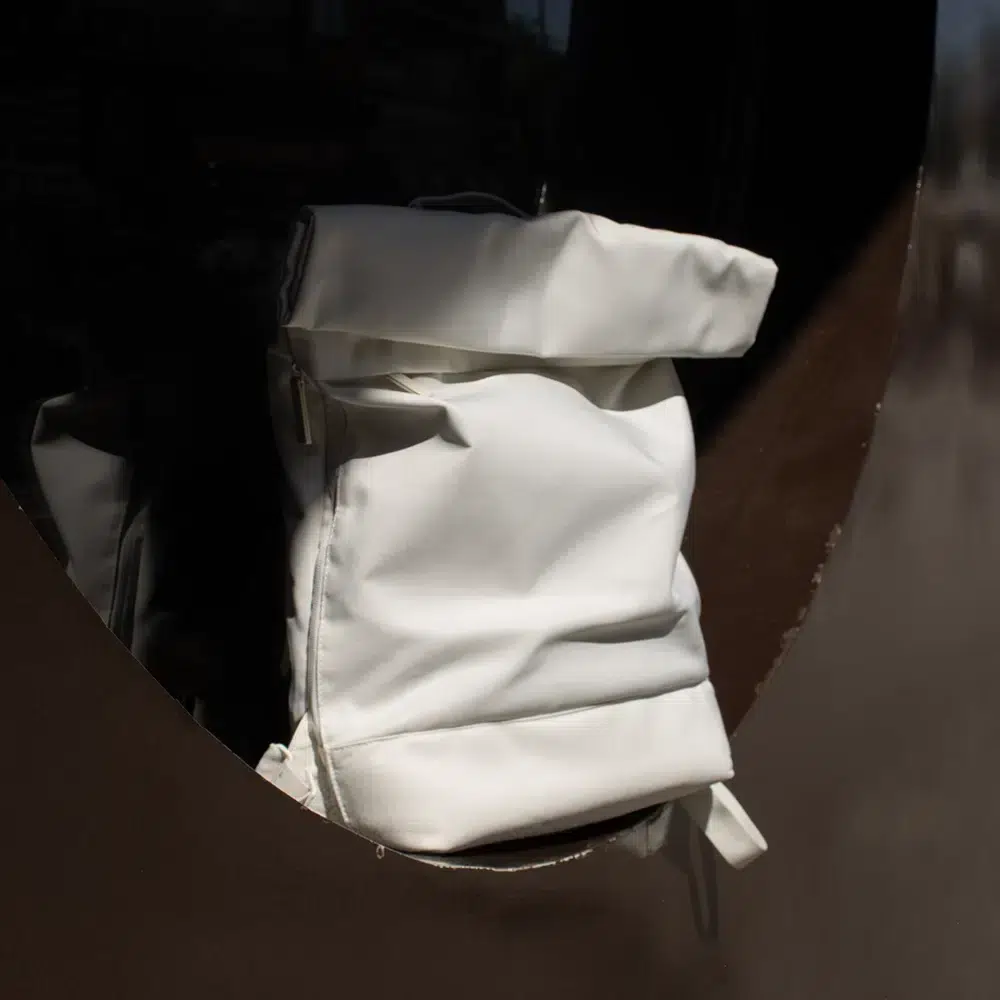 Mochila roll top personalizada blanca sobre una ventana circular de color marrón