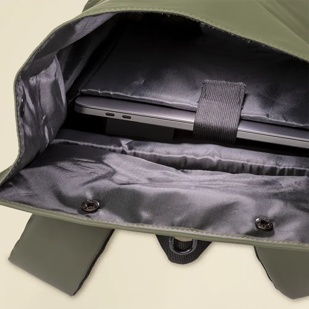 Mochila reciclada con cierre roll top abierta con un portátil en su interior