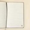 Cuaderno ecológico personalizado abierto sobre una superficie beige