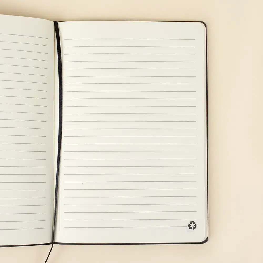 Cuaderno ecológico personalizado abierto sobre una superficie beige