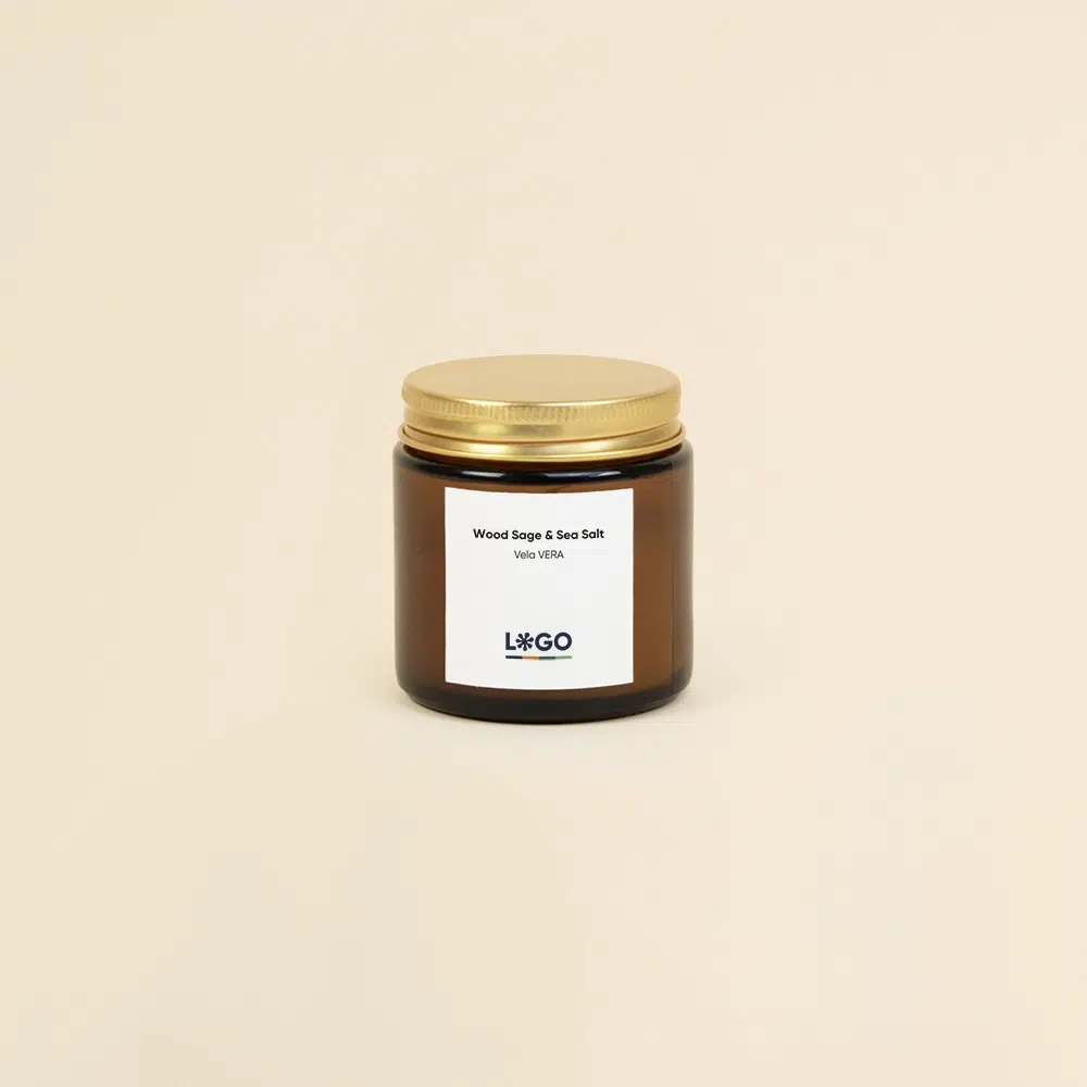 Vela aromática personalizada con tapa metálica sobre un fondo beige