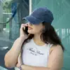 Gorra vintage VINTY Chica hablando por teléfono con una gorra vintage azul