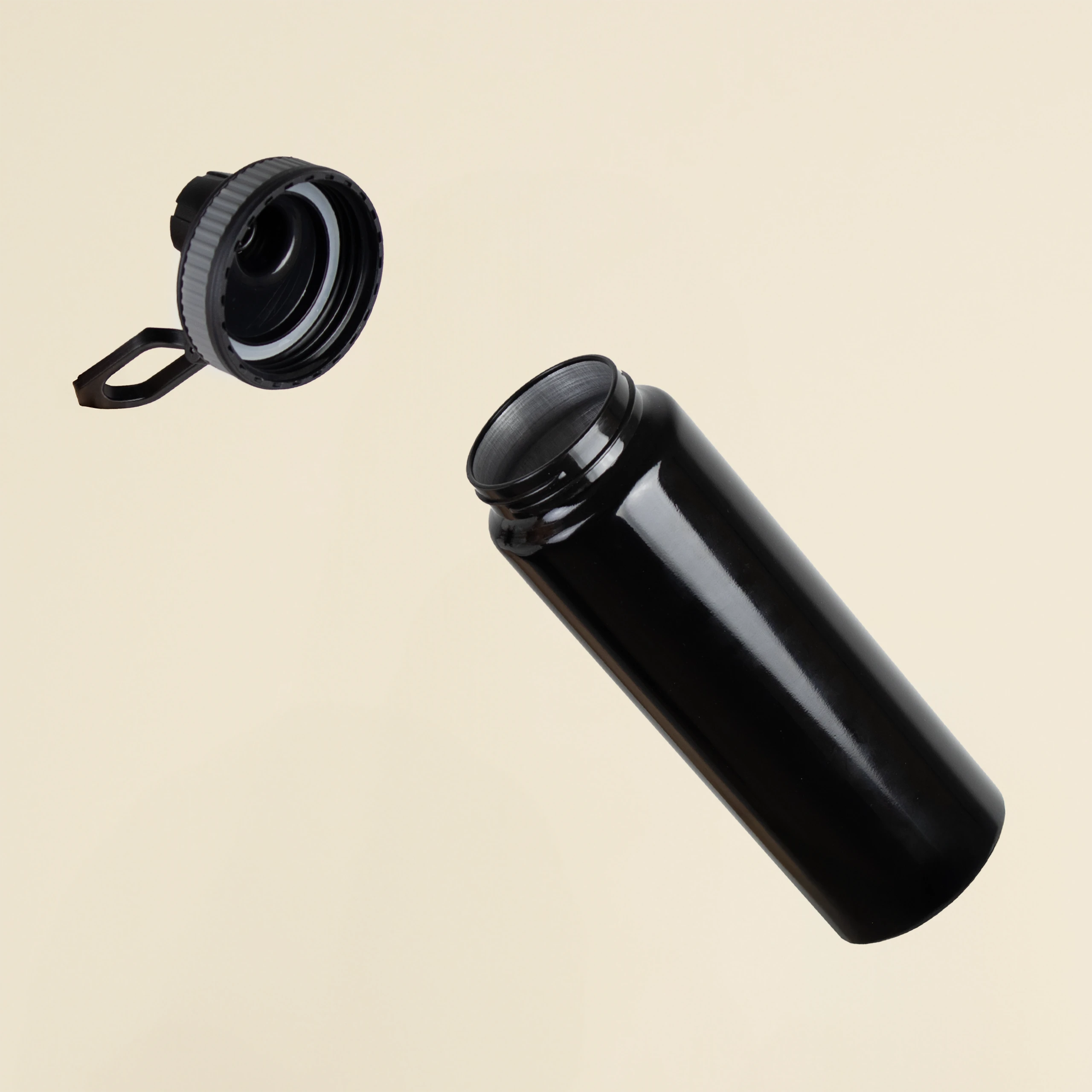 Botella deportiva negra personalizada en aluminio reciclado abierta sobre un fondo beige