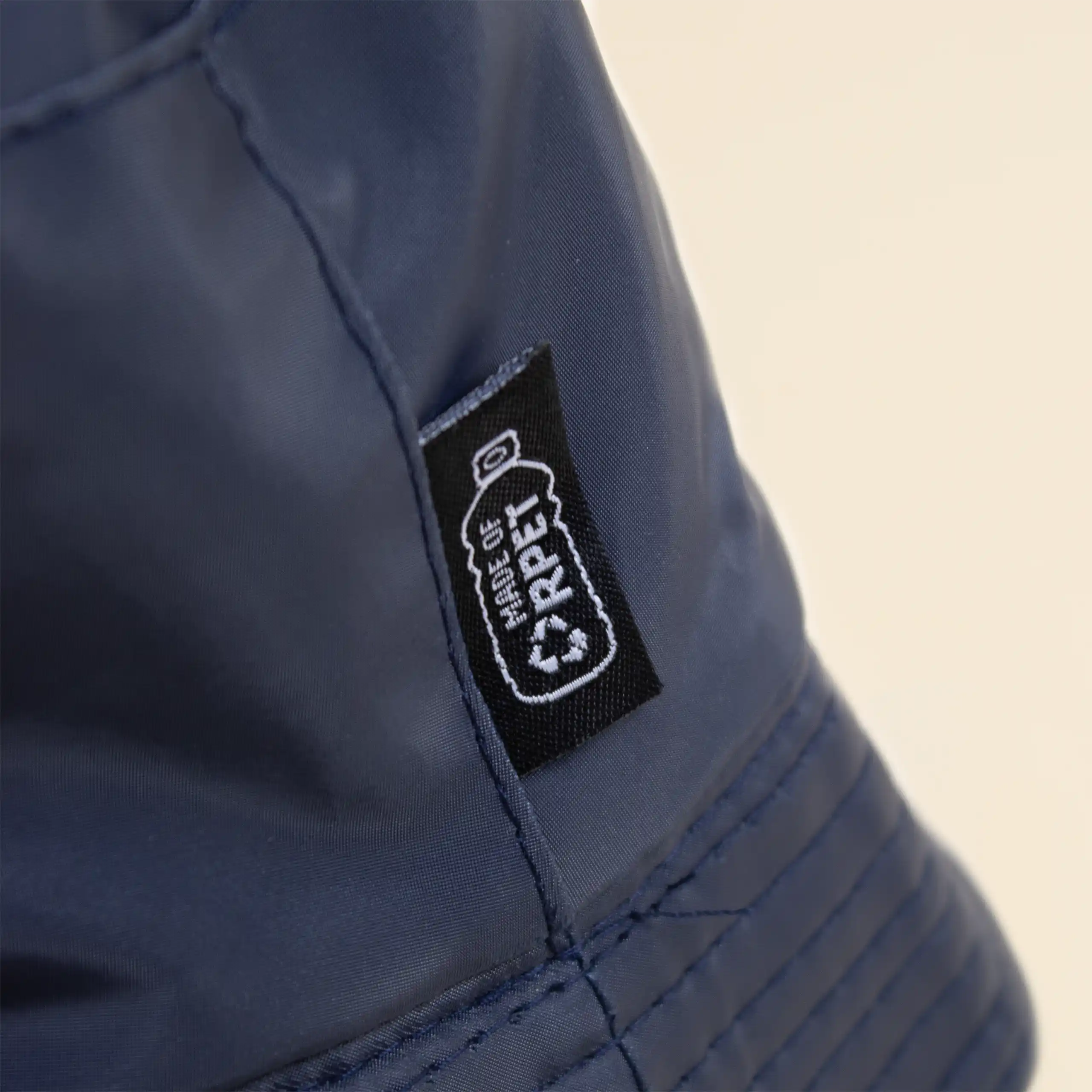 Gorro azul impermeable reversible ecológico personalizado sobre un fondo beige