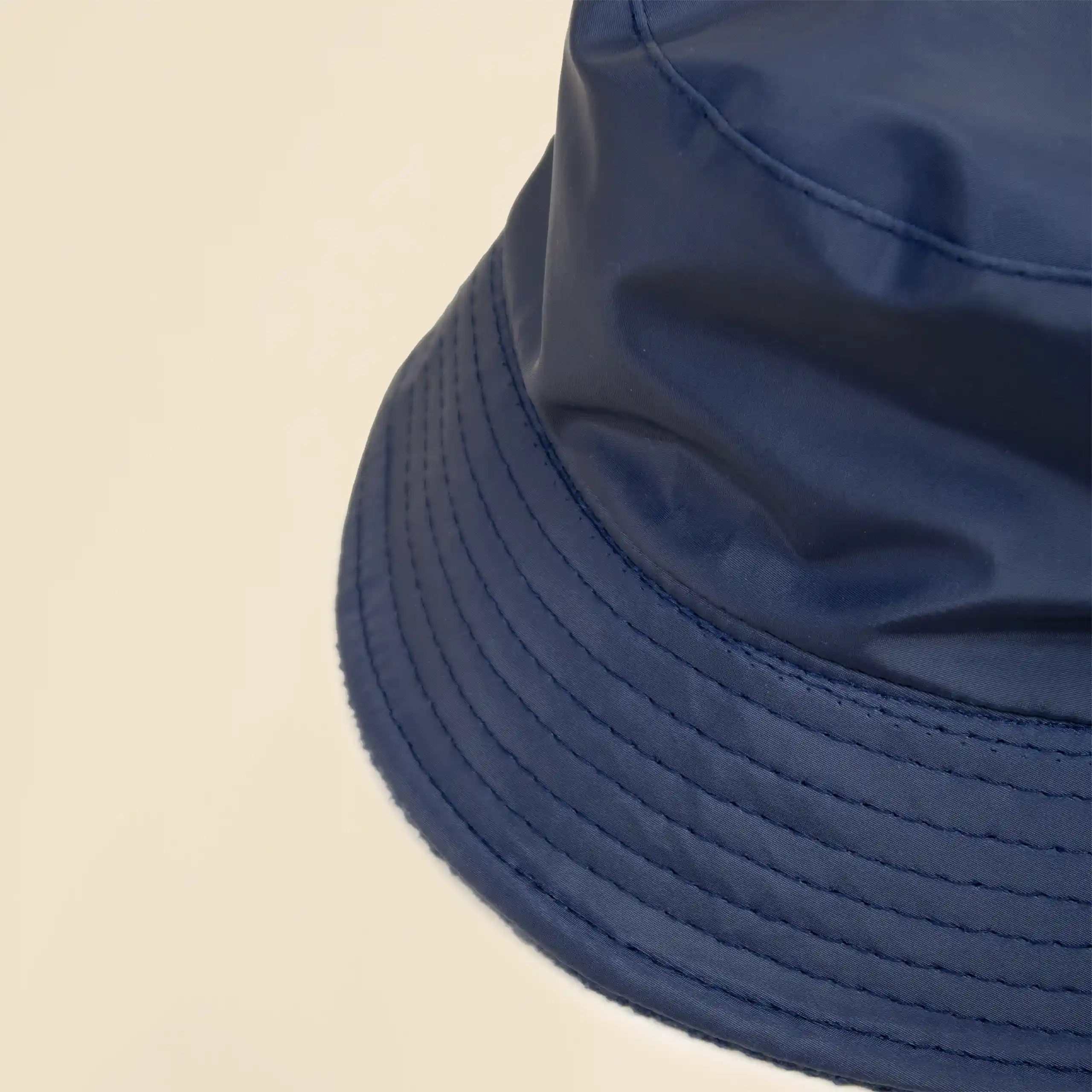 Gorro azul impermeable reversible ecológico personalizado sobre un fondo beige