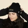 Chica con gorro negro ecológico personalizado sobre fondo beige