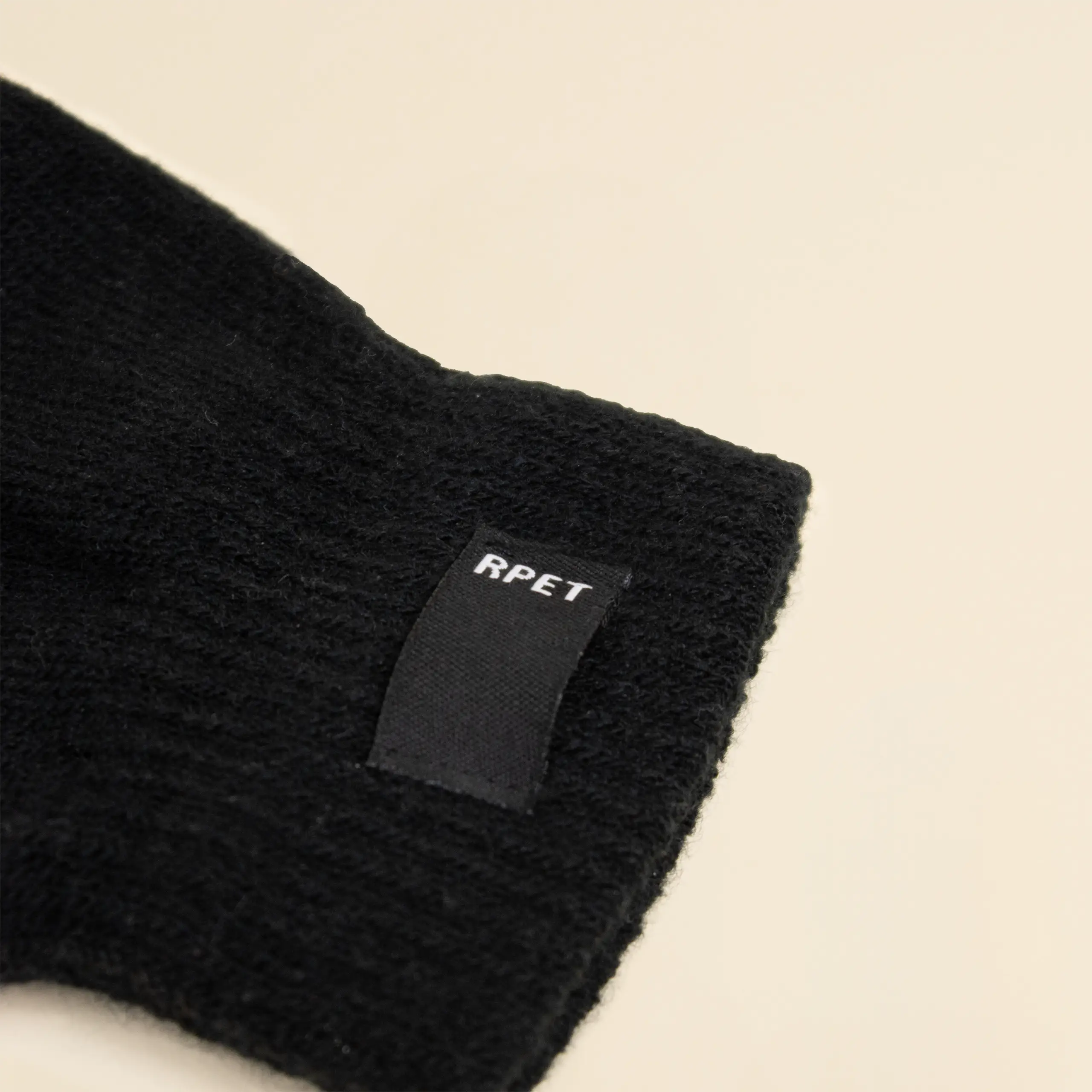 Guantes personalizados KLEAN con etiquetaa rPET sobre fondo beige