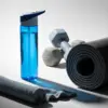Botella de gimnasio azul junto con material deportivo