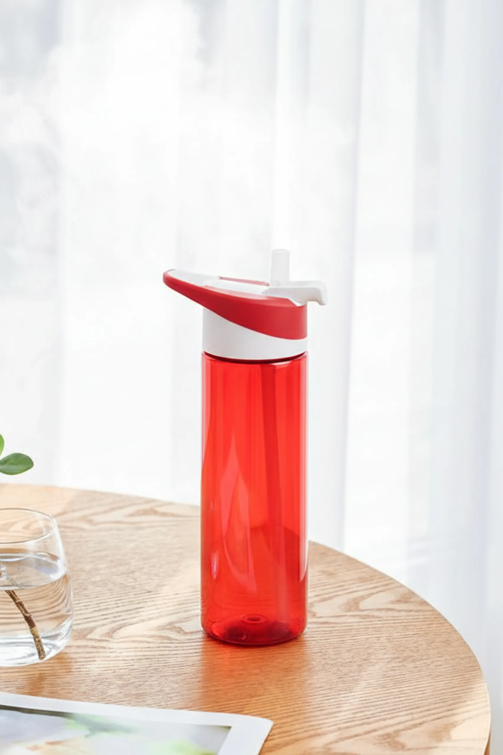 Botella de gimnasio roja sobre una mesa de madera