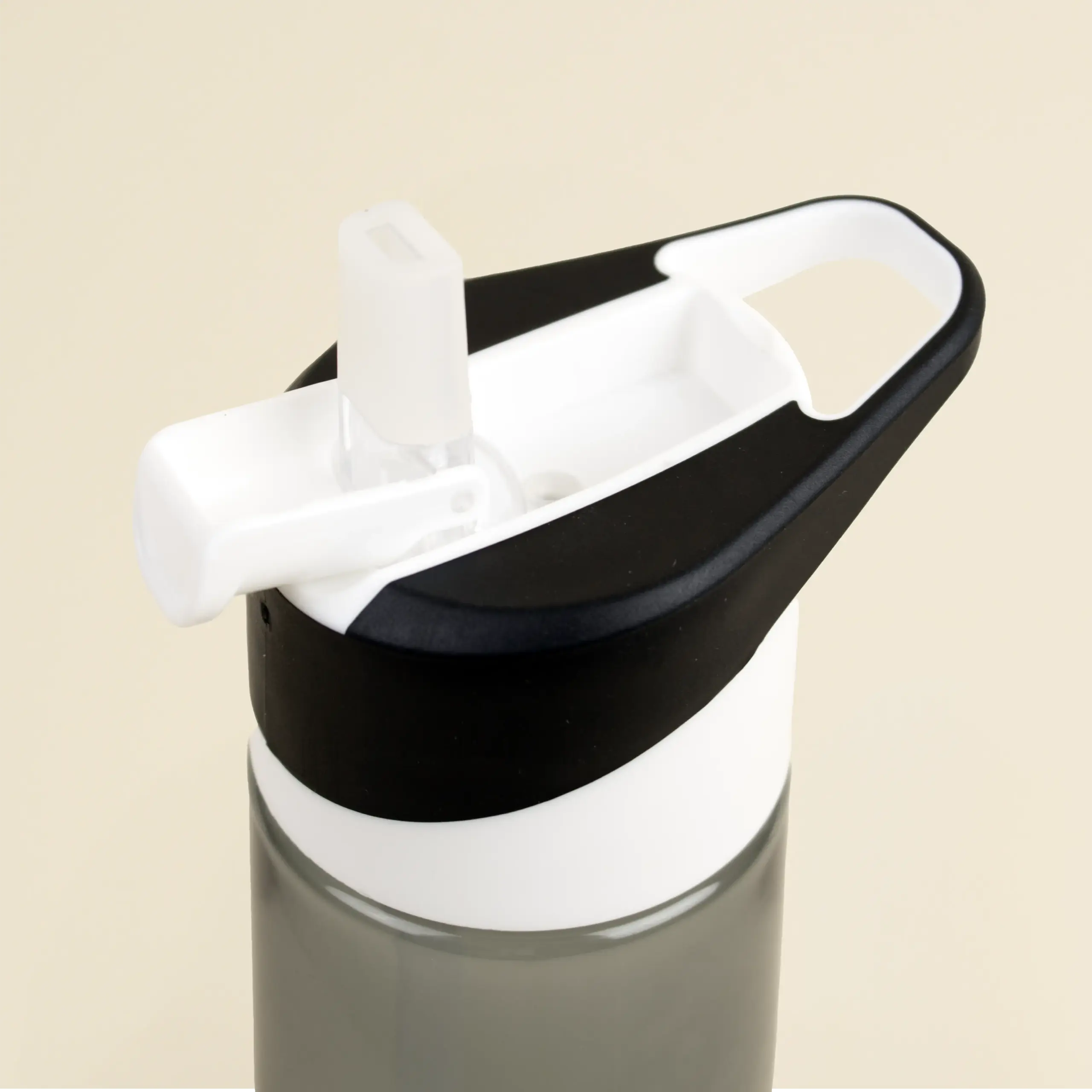 Boquilla de una botella de gimnasio negra sobre un fondo beige