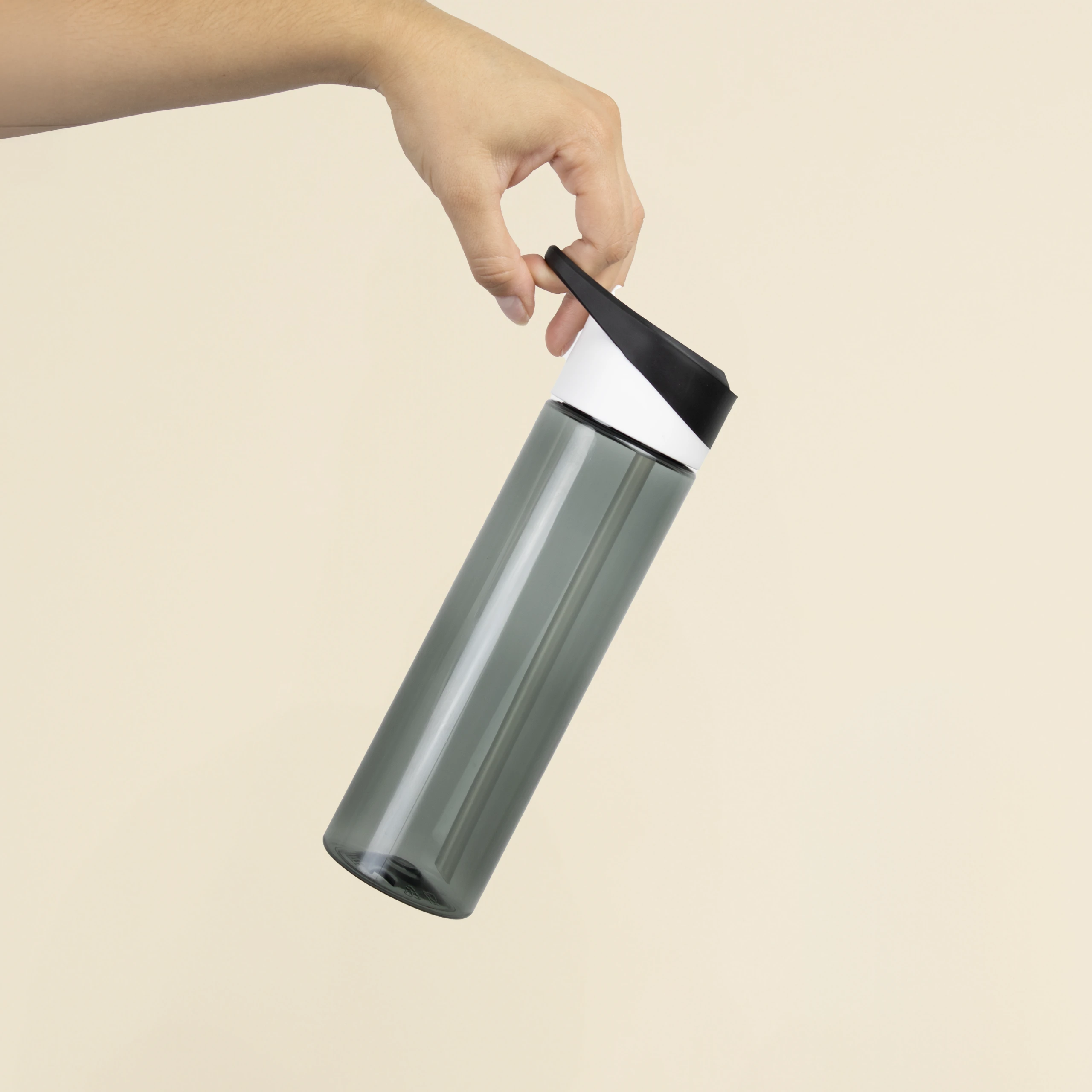 Mano sosteniendo una botella de gimnasio negra sobre un fondo beige