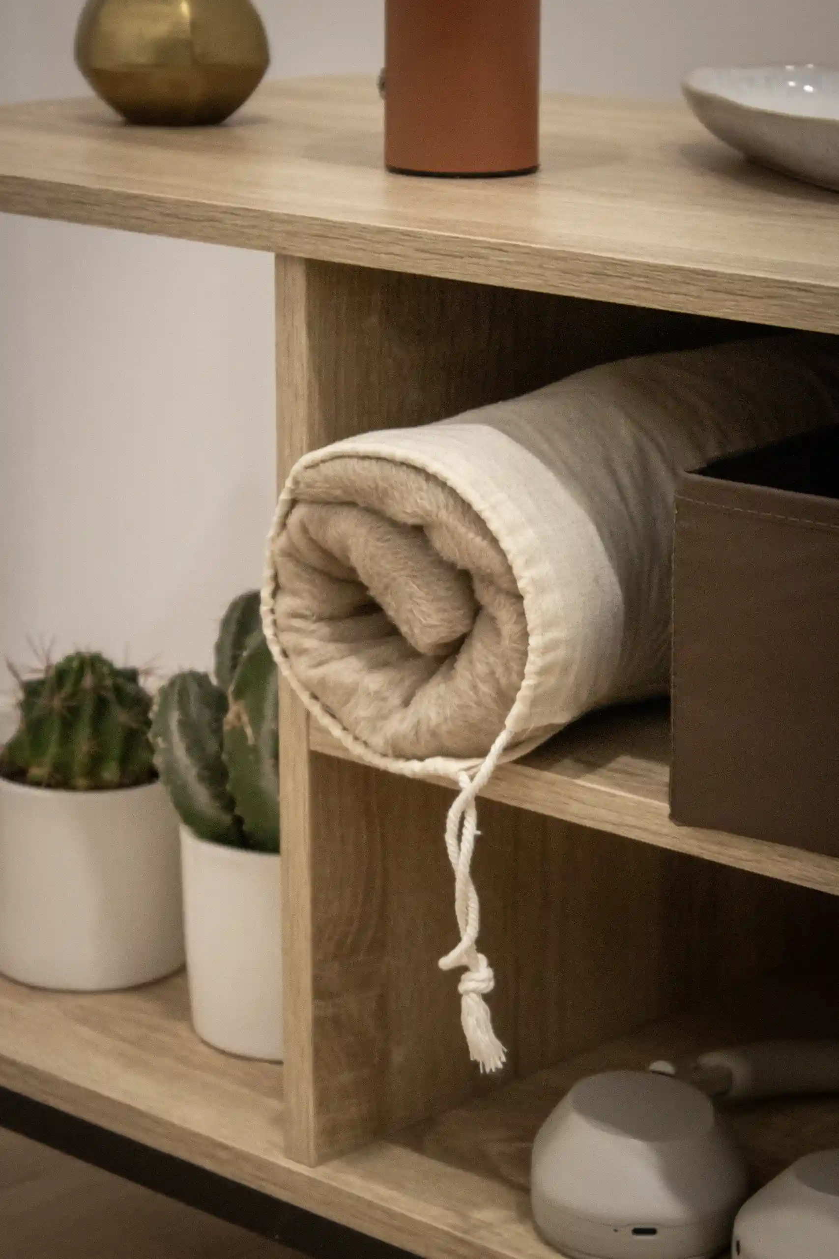 Manta ecológica personalizada con funda de algodón guardada en una estantería