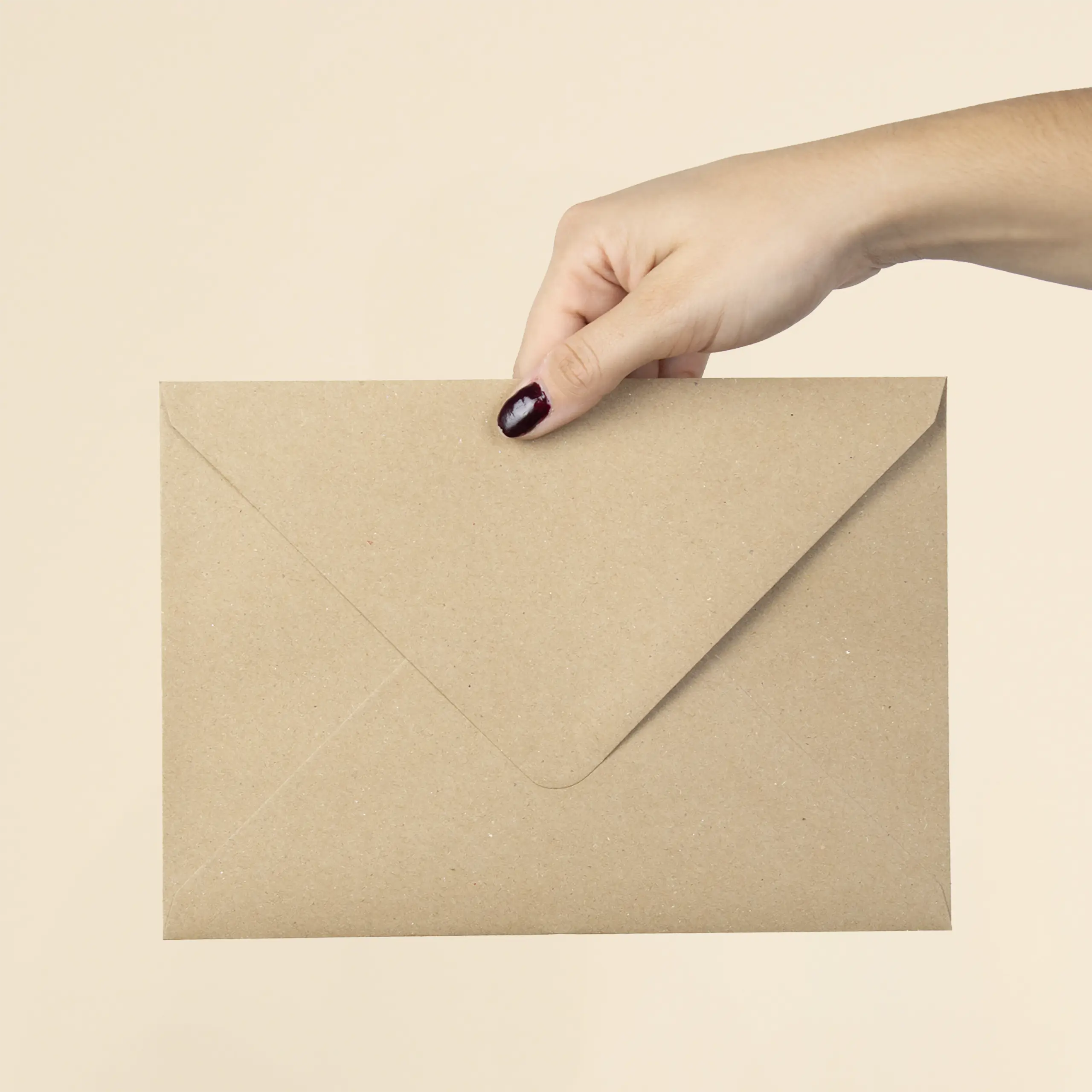 Mano mostrando la trasera de un sobre kraft en formato C5