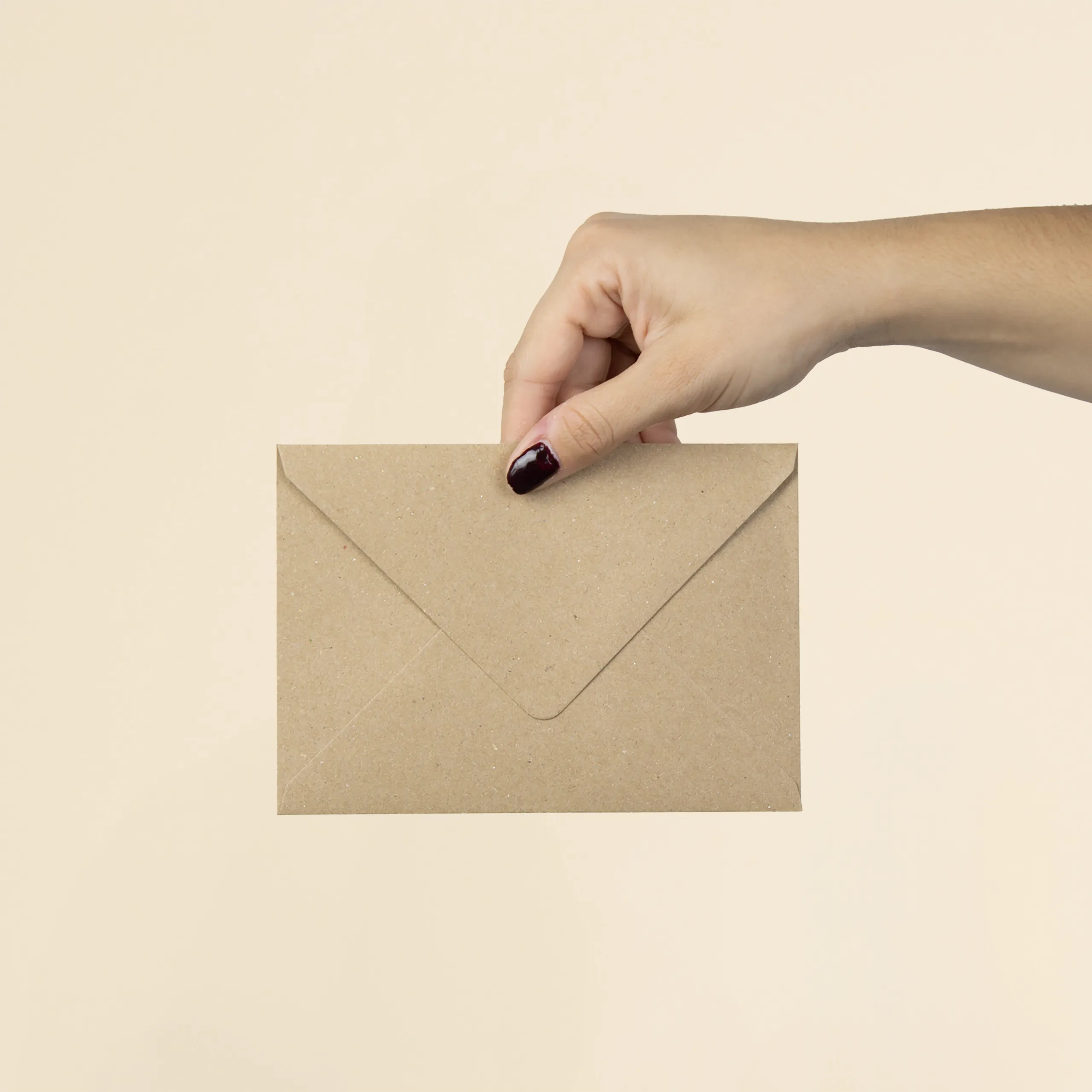 Mano mostrando la trasera de un sobre kraft en formato C6