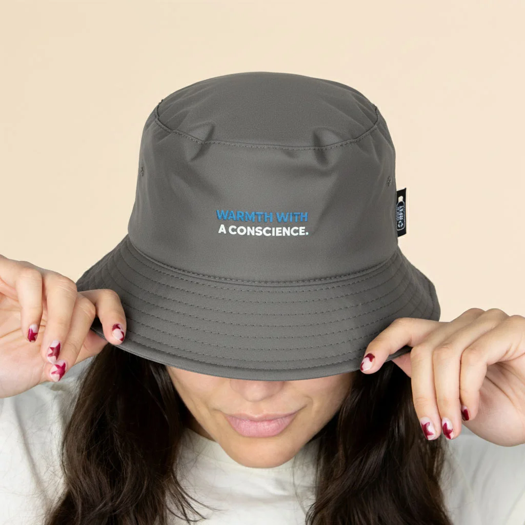 Chica con un gorro verde impermeable reversible ecológico sobre un fondo beige