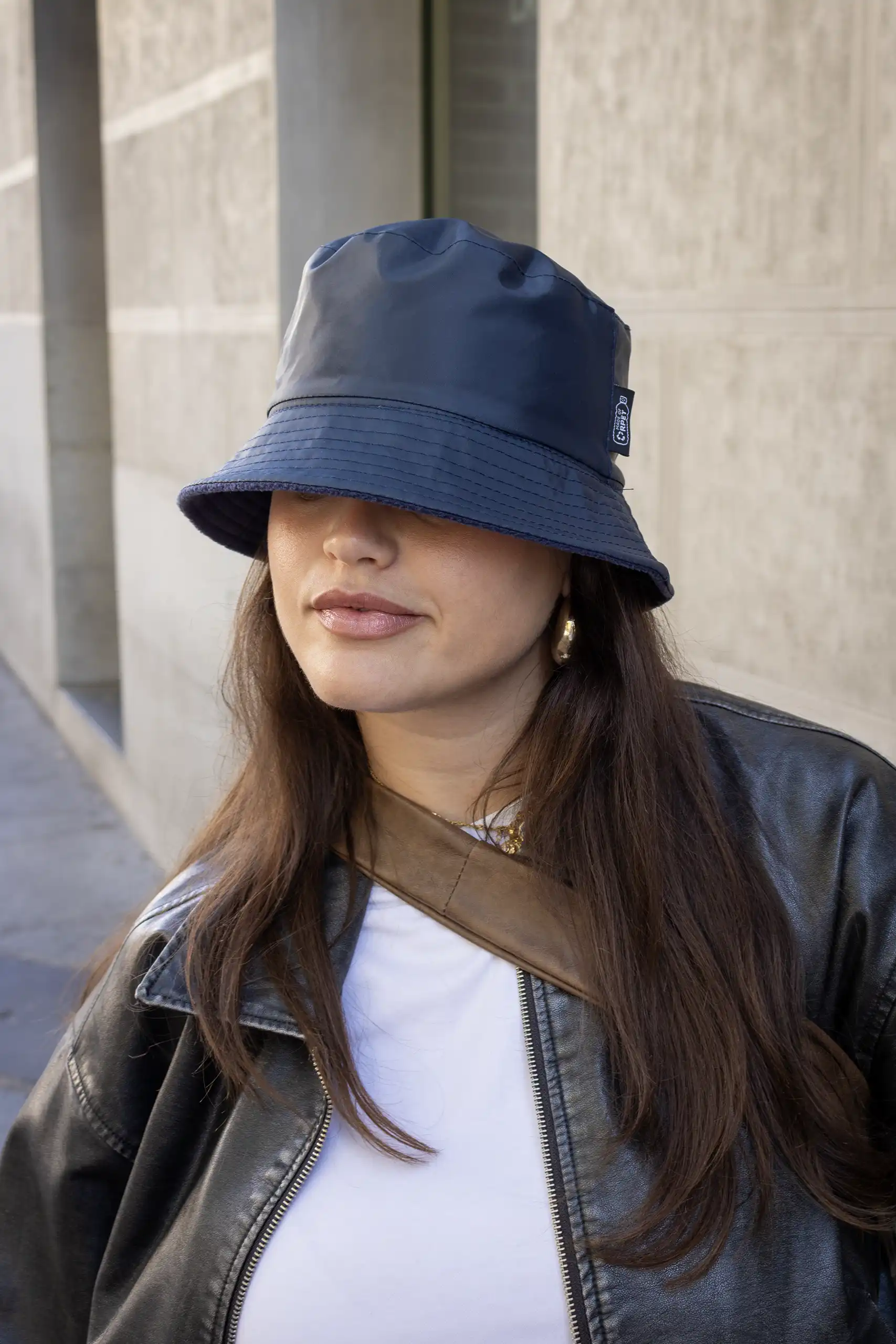 Chica mirando a cámara con gorro azul reversible impermeable personalizado